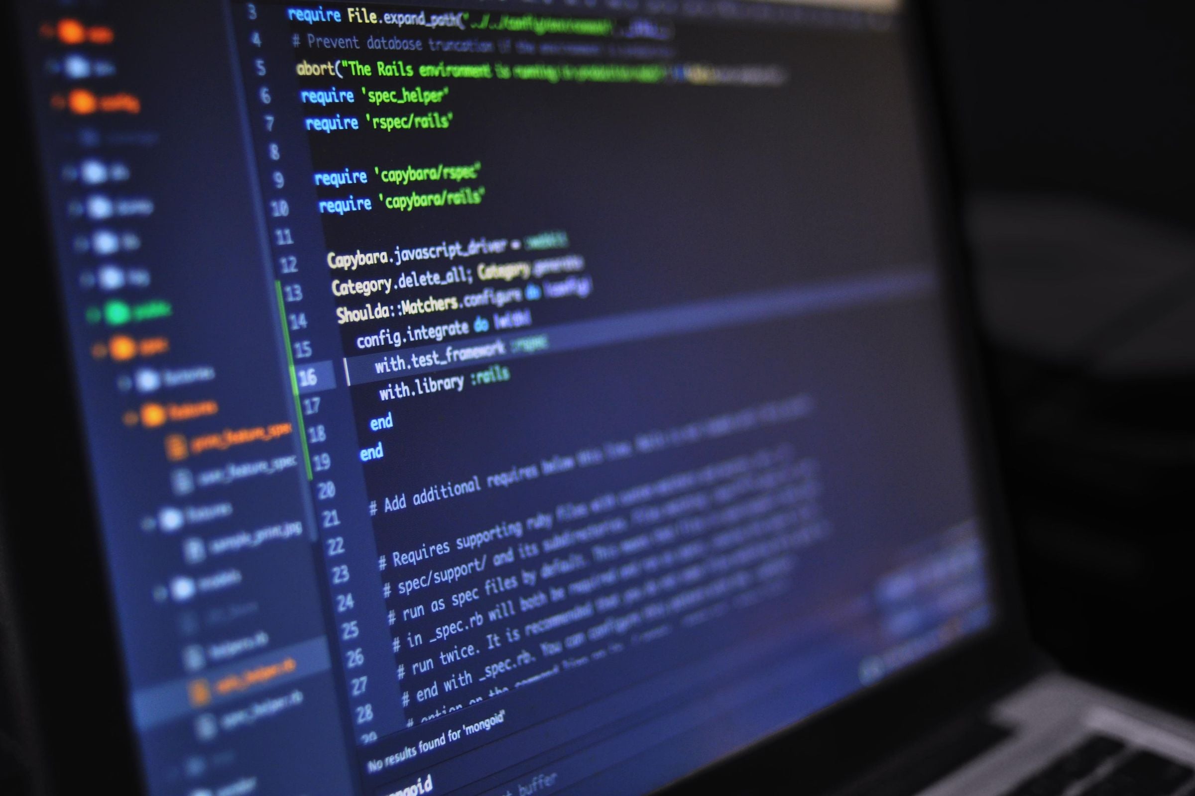 Code on a laptop screen in a dark room